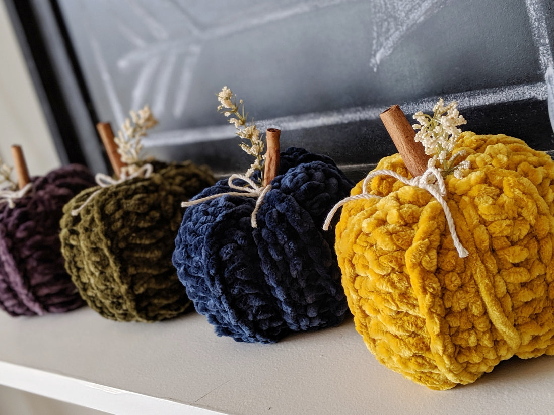 velvet crochet pumpkins in a row on a shelf